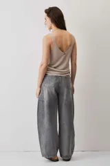 Jeans de corte barrel en tono gris deslavado, con diseño amplio y tachas decorativas a lo largo de las costuras laterales y los bolsillos delanteros.