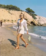 Shorts de cuero color coral, tiro alto, con bolsillos laterales y cierre frontal con botón.