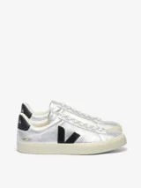Zapatilla Veja modelo Campo, confeccionada en cuero bovino con acabado metalizado plateado. Presenta el logo de la marca en contraste negro en el lateral, detalle en el talón y suela de goma en tono crema.