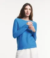 Blusa de punto color celeste con textura ondulada, cuello redondo y mangas largas.