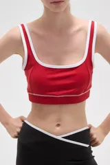 Top deportivo negro con detalles de ribete blanco en el escote y breteles. Presenta un diseño de corte cuadrado y ajuste al cuerpo.