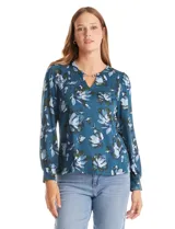 Blusa de manga larga con estampado floral en tonos verdes y azules. Presenta un escote en V con un detalle metálico decorativo y puños ajustados.