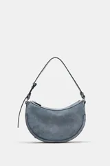 Bolso bandolera de piel color gris con diseño ovalado tipo media luna. Cuenta con cierre de cremallera, asa corta de hombro ajustable y detalles metálicos.