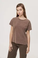 Remera de manga corta y cuello redondo, con calce relajado y efecto lavado, decorada con apliques de strass en la parte superior.