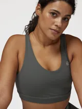 Top deportivo de sujeción media con diseño de espalda cruzada y escote redondo. Presenta un ajuste al cuerpo y cuenta con un pequeño logo estampado en el frente.