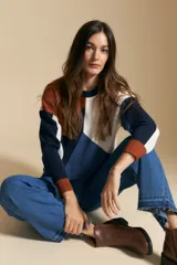 Sweater de punto con diseño geométrico de bloques de color en tonos azul marino, blanco y terracota. Presenta cuello redondo, mangas largas con puños acanalados y una silueta relajada.