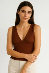 Musculosa negra de poliéster, ajustada al cuerpo, con escote en V y detalle de encaje en el borde del escote.