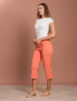 Pantalón capri blanco de gabardina elastizada. Pretina ancha elastizada, delantera con bolsillos simulados y trasera con bolsillos aplicados.