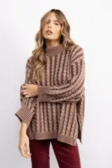 Sweater de tejido de punto con diseño de trenzas verticales, cuello redondo alto y silueta oversize. Presenta aberturas laterales en el ruedo y mangas largas con puños acanalados.