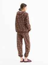 Pantalón jogging marrón con estampado de labios, cintura elástica con cordón ajustable y puños en los tobillos.