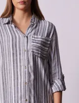 Camisa de lino a rayas grises, blancas y negras, con cuello clásico, escote en V, abertura frontal con botones y bolsillo de parche en el pecho.