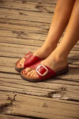 Sandalias de cuero color marrón con hebilla metálica plateada.