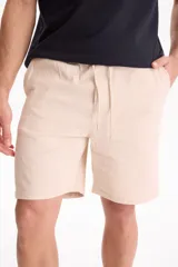 Bermuda de gabardina con spandex, cintura elastizada y cordón ajustable, de corte recto y color azul marino.