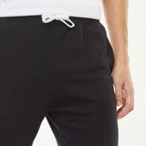 Pantalón de jogging negro, corte recto y tobillos ajustados.