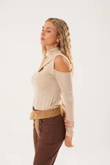 Polera beige de cuello alto con mangas largas y abertura en el pecho.