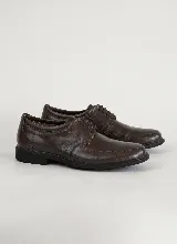 Zapato de vestir tipo derby, confeccionado en cuero legítimo color marrón oscuro, con cordones al tono, costuras reforzadas y suela de goma negra.