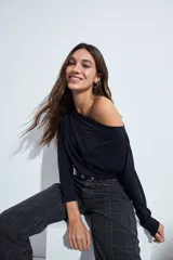 Top de manga larga con escote bote amplio, diseñado para usar ligeramente caído sobre los hombros. Presenta una silueta entallada y tejido liso, liviano y adaptable al cuerpo.