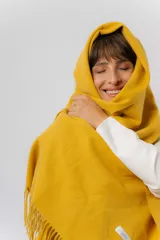 Bufanda tejida de textura suave y liviana, con terminación de flecos en los extremos.