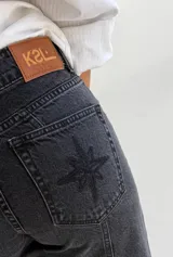 Pantalón de jean recto de tiro medio color gris oscuro con costuras verticales.