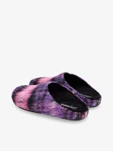 Clog tipo mula con parte superior de tela peluda con patrón de rayas en tonos morado, rosa y negro.