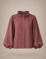 Camisa de lino color marrón chocolate, con cuello redondo adornado con volados, cierre frontal de botones y mangas largas abullonadas con puños ajustados.