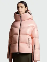 Campera puffer rosada con capucha integrada, cierre frontal con cremallera y bolsillos laterales con cierre.