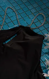 Traje de baño enterizo blanco con breteles finos y abertura en el pecho.