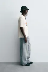 Jeans de denim de algodón, color azul oscuro con efecto lavado. Presentan un corte muy holgado (baggy fit) en toda la pierna y tiro medio. Tienen cinco bolsillos y cierre frontal con cremallera y botón.