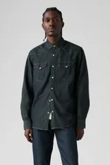 Camisa de denim azul oscuro con corte clásico, mangas largas, cierre con botones a presión, dos bolsillos frontales con solapa y costuras decorativas en los hombros.