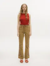 Pantalón de jean estilo oxford y tiro alto, color tostado, con apliques metalizados en forma de tachas que bordean los laterales y costuras.