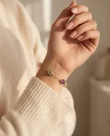 Pulsera de cadena fina con baño de oro, adornada con piedras naturales de diferentes colores y texturas, incluyendo una piedra con patrón de puntos y una piedra amatista.