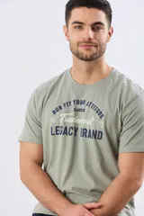 Remera verde pistacho de manga corta y cuello redondo, con diseño gráfico estampado en el frente con inscripciones y tipografías en tonos oscuros y blancos.