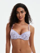 Soutien con estampado floral en tonos lila y blanco, con breteles regulables y detalle de puntilla en el borde superior de las copas.