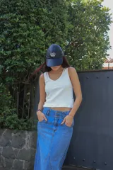 Falda larga de jean azul claro, con tajo trasero, pretina con doble botón y cierre metálico.