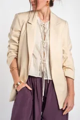 Blazer de algodón peinado, color beige, de calce al cuerpo con solapas clásicas y mangas largas.