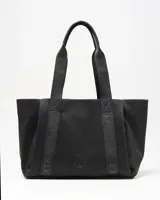 Cartera tipo tote de color negro con asas de hombro decoradas con inscripciones grabadas y detalle de aplique circular con logo en la parte frontal.