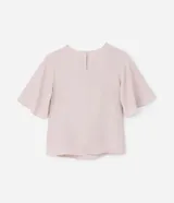 Blusa de crepé color rosa pálido, con cuello redondo, mangas cortas con volados, lazo en la cintura y botón en la espalda.
