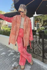 Kimono de jean con estampado paisley tipo bandana, color rojo y tostado, con mangas largas y diseño abierto.