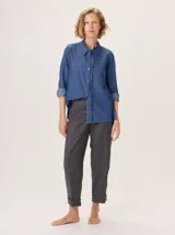 Camisa de algodón con cuello clásico y detalle de volados en la cartera delantera. Presenta mangas largas con puños abotonados y un diseño de corte recto.