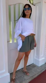 Short de lino color rojo, con cintura elástica y cinturón de rafia con hebilla circular.