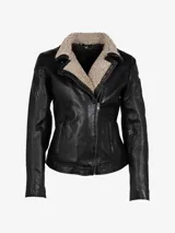 Chaqueta de cuero negra con cuello de piel de oveja color crema, cierre frontal con cremallera asimétrica y corte entallado.