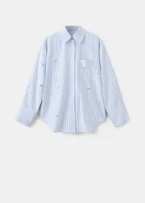 Camisa de popelina celeste a rayas, de corte oversize, con cuello camisero, mangas largas y aplicaciones de pedrería y lentejuelas brillantes distribuidas por toda la prenda.