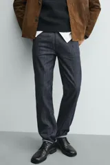 Jeans de corte slim fit en color azul oscuro, con diseño de cinco bolsillos, cierre frontal con cremallera y botón, y tejido ligeramente elástico.