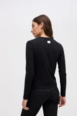 Remera de manga larga con cuello redondo, confeccionada en tejido rib con textura acanalada y calce ajustado al cuerpo.