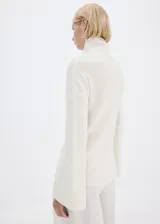 Chaleco de punto blanco de cuello alto y diseño recto, confeccionado con mezcla de acrílico, poliéster, poliamida y lana.