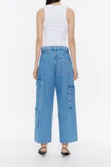 Pantalón cargo de denim celeste, corte ancho, tiro medio, con bolsillos laterales con solapa y cierre de botón y bolsillos delanteros y traseros.