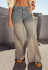 Pantalón de jean celeste con efecto degradado, corte acampanado y detalles de roturas.