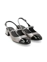 Zapato destalonado tipo slingback con taco bajo cuadrado de acabado metálico. Presenta cuerpo en cuero color plomo y puntera en cuero charol negro, con tira ajustable en el empeine y cierre de hebilla.