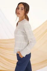 Sweater lila con rayas horizontales color crudo, de corte holgado y cuello redondo.