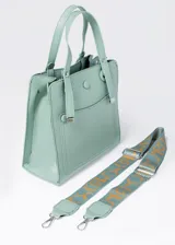 Cartera color beige de cuero sintético, con doble asa corta y correa larga extraíble con estampado de letras en dorado.